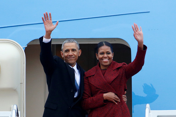 Former president Barack Obama waves with his wife Michelle as they board Special Air Mission 28000, a Boeing 747 which serves as Air Force One, at Joint Base Andrews